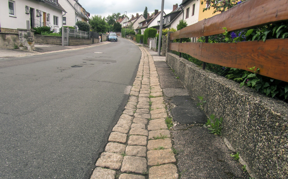 Der „Gehweg“: Fußgänger haben keine Wahl und müssen die Fahrbahn nutzen. Kinder zum Spielplatz, Schüler zur Realschule/auf dem Schulweg.